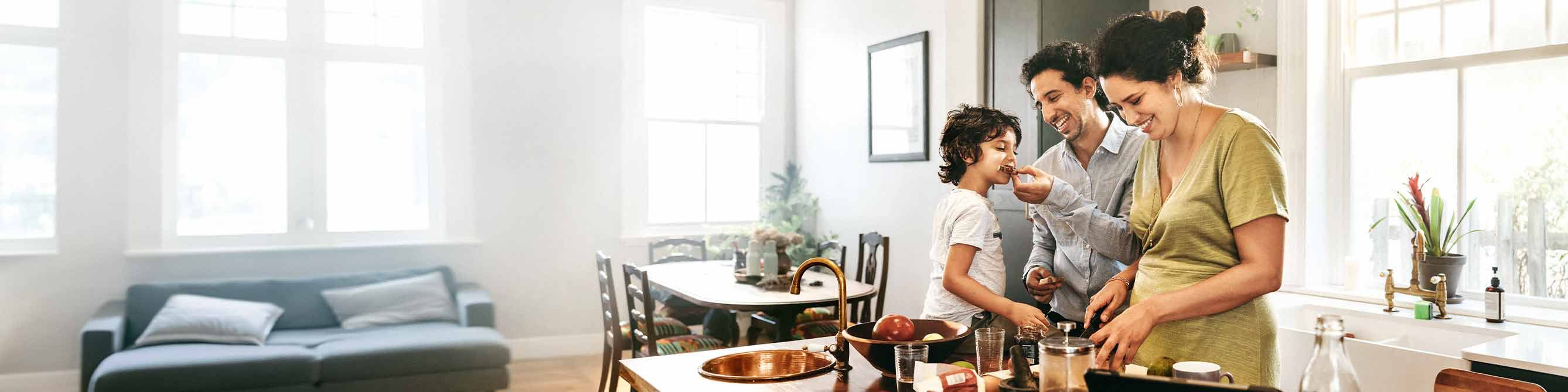 Hausratversicherung: Mutter, Vater und Kind kochen gemeinsam in der Küche. 
