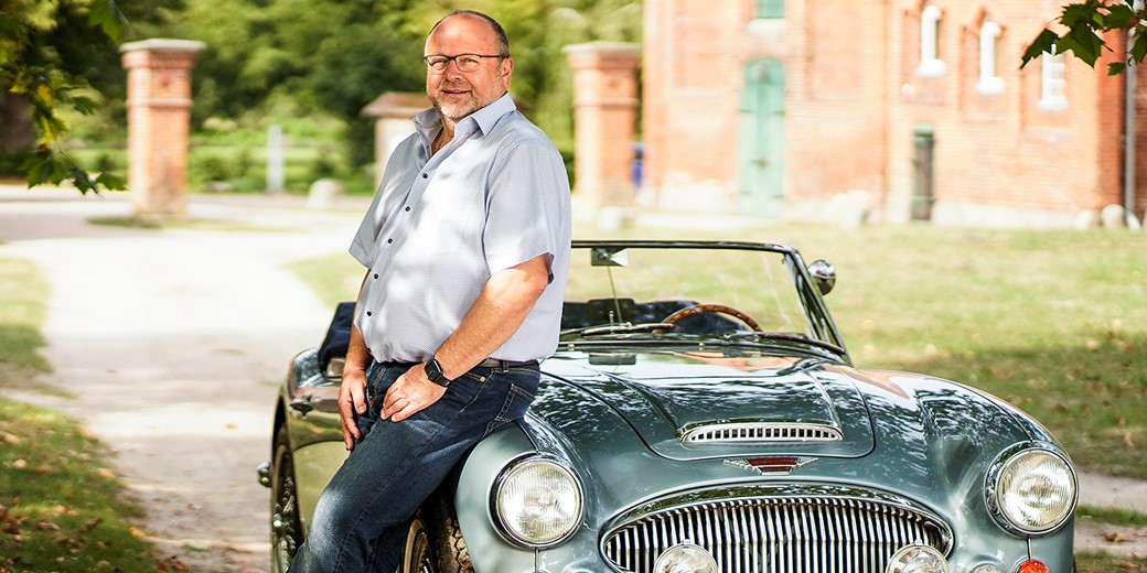 Mann der sich gegen Fahrzeug lehnt