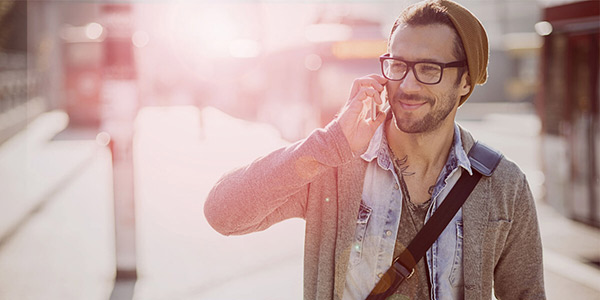 MEINRECHT Tarif ab 2020: Lächelnder Mann mit Brille und Mütze spricht am Smartphone
