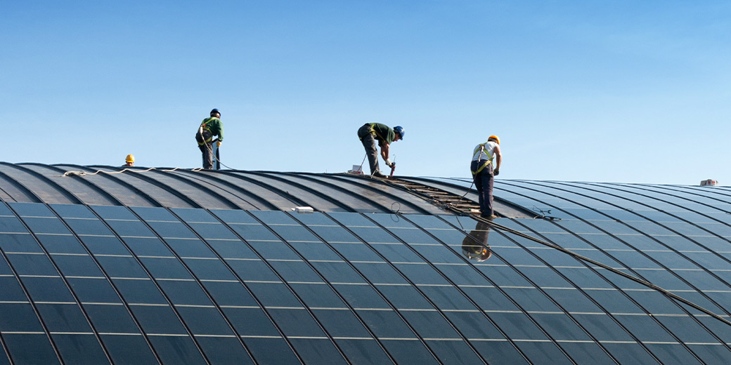 Arbeiter bauen eine große Solaranlage auf.