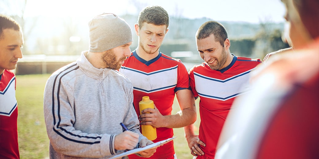 Vereine: Ein Trainer gibt seiner Mannschaft Anweisungen.