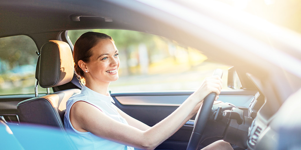 Verkehrsrechtsschutzversicherung. Lächelnde Frau im Auto